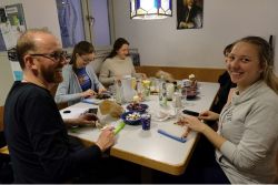 Jugendliche mit Pfarrer am Tisch